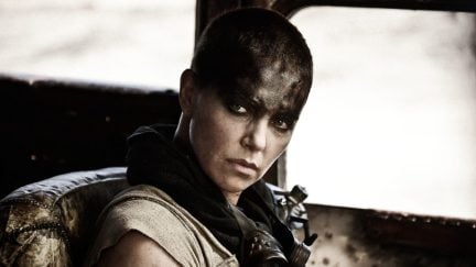 charlize theron as Furiosa, looking at someone from the driver's seat.