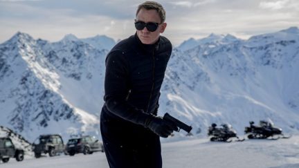 James Bond standing in the mountains with sunglasses on in Spectre