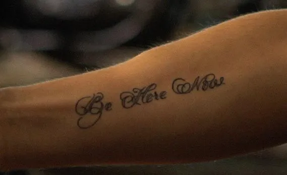 Be Here Now arm tattoo