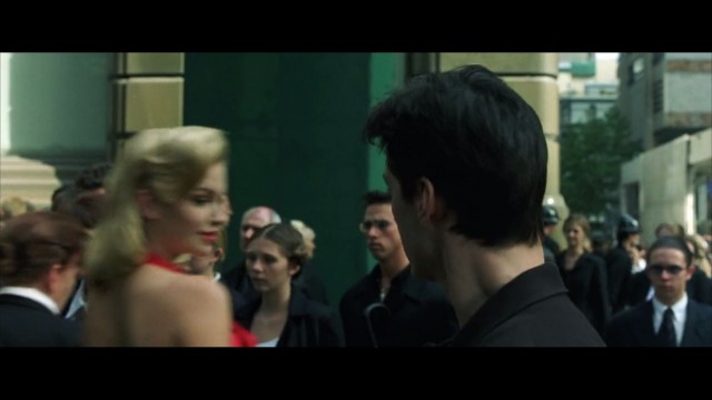 Neo sees the woman in the red dress.