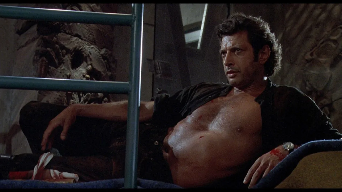 Jeff Goldblum reclines shirtless in 'Jurassic Park'.