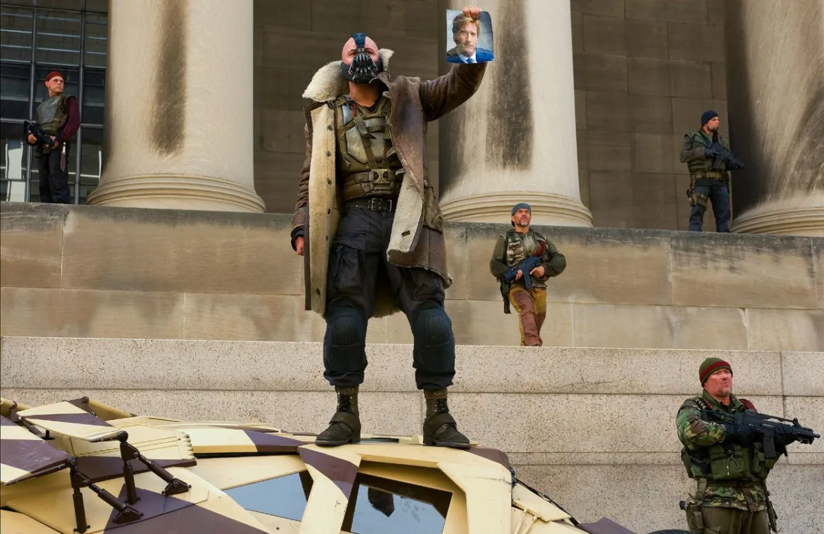 bane from the dark knight rises holding a pic of harvey dent.