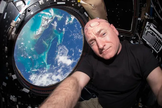 Scott Kelly during his Year in Space aboard the ISS, with a view of Earth in the foreground. Photo Credit: NASA
