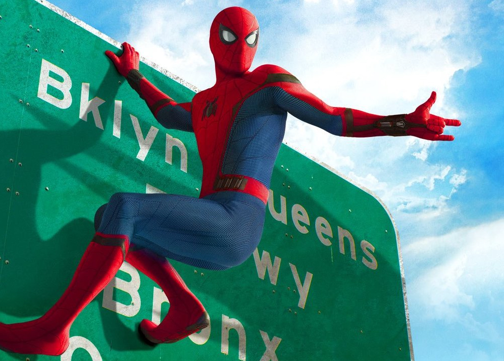 Spider-Man hanging from a highway sign.