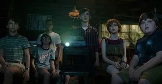 A group of kids watch a movie in IT.