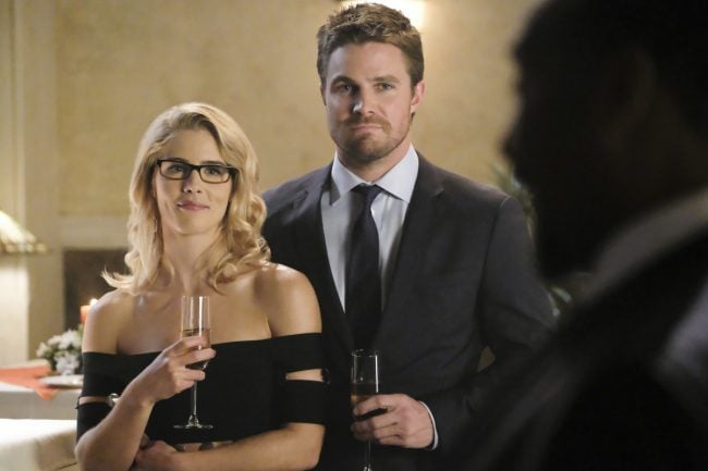 image: Bettina Strauss/The CW Supergirl -- "Crisis on Earth-X, Part 1" -- Pictured (L-R): Emily Bett Rickards as Felicity Smoak and Stephen Amell as Oliver Queen -© 2017 The CW Network, LLC. All Rights Reserved