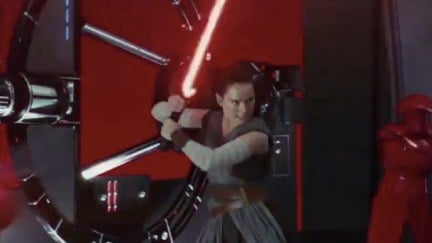 Rey with Kylo's lightsaber in Star Wars: The Last Jedi