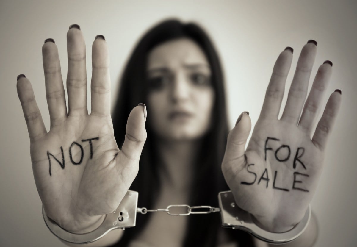 woman in handcuffs with "not for sale" written