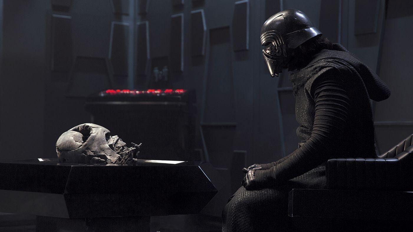 Adam Driver as Kylo Ren looking at Darth Vader's helmet in Star Wars: The Force Awakens