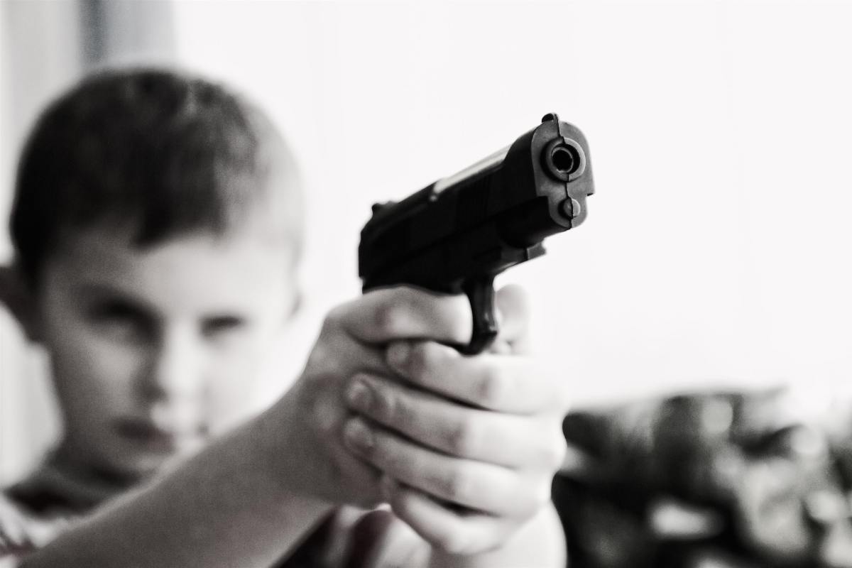 Young boy holding gun. 