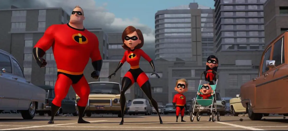 An animated superhero family in "Incredibles 2" stand in the middle of the city with surprised looks on their faces.