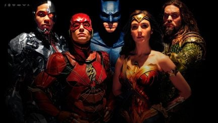 The Justice League posing together against a black background facing the screen.