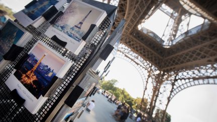 Postcards are displayed under The Eiffel Tower in Paris on August 2, 2018. - The Eiffel Tower was turning away tourists for a second day as workers pressed a strike over a new access policy which they say is causing unacceptably long wait times for visitors. The monument has been closed since August 1, as unions locked horns with management over a decision to assign separate elevators to visitors with pre-booked tickets and those who buy them on site. (Photo by GERARD JULIEN / AFP) (Photo credit should read GERARD JULIEN/AFP/Getty Images)