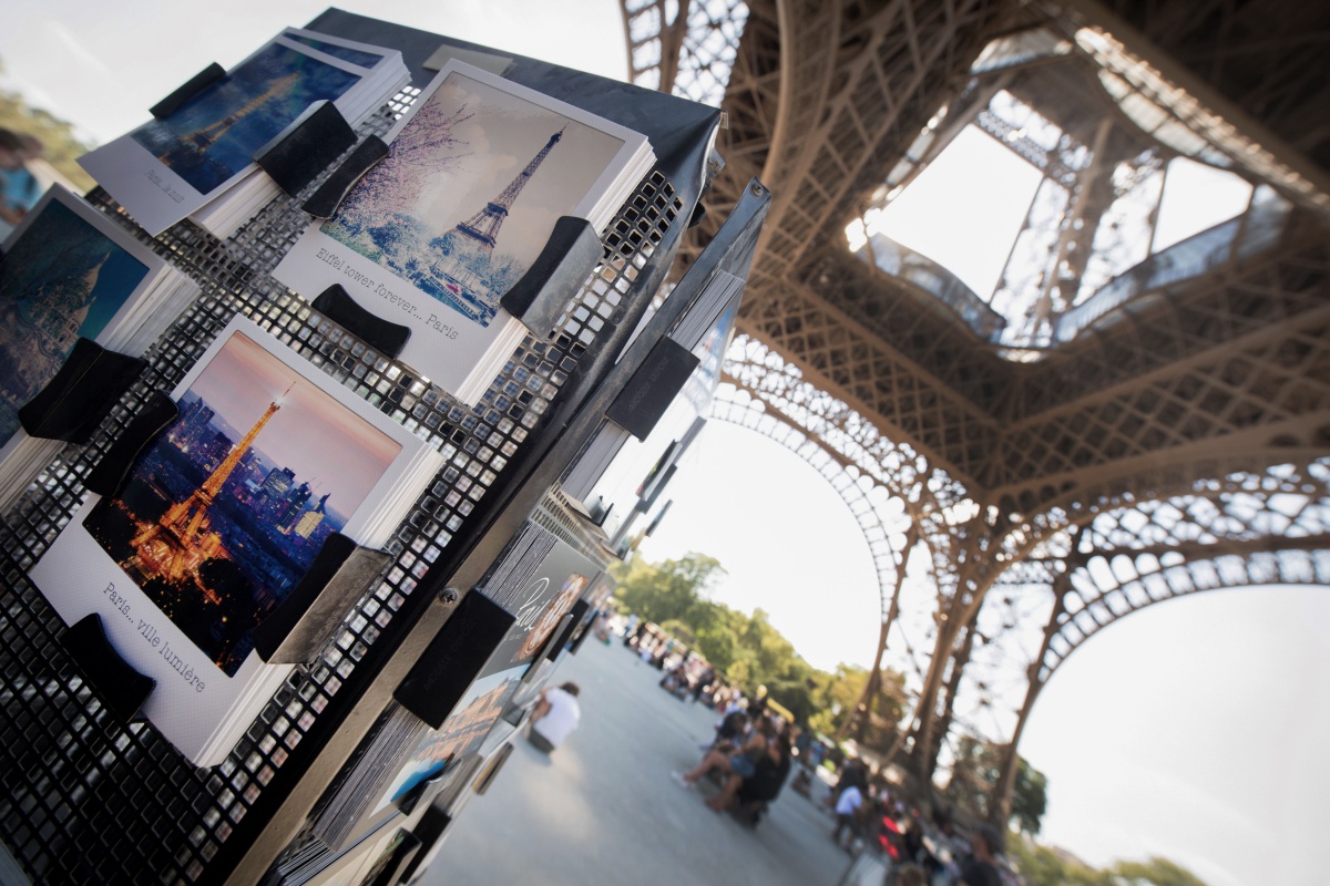 Postcards are displayed under The Eiffel Tower in Paris on August 2, 2018. - The Eiffel Tower was turning away tourists for a second day as workers pressed a strike over a new access policy which they say is causing unacceptably long wait times for visitors. The monument has been closed since August 1, as unions locked horns with management over a decision to assign separate elevators to visitors with pre-booked tickets and those who buy them on site. (Photo by GERARD JULIEN / AFP) (Photo credit should read GERARD JULIEN/AFP/Getty Images)