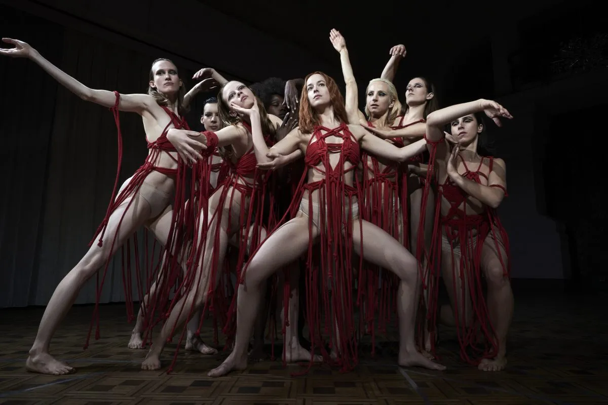 Mia Goth as Sara and Dakota Johnson as Susie star in "Suspiria" wearing red rope dresses.
