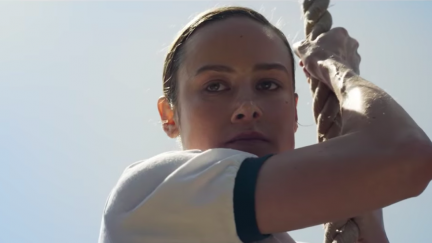 Brie Larson climbs a rope as Carol Danvers in Captain Marvel.