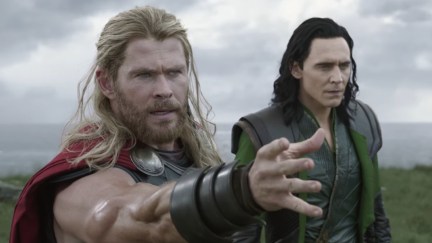 Thor (Chris Hemsworth) and Loki (Tom Hiddleston) stand beside each other as Thor summons his hammer.