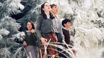 Four children stand in a snowy landscape, looking around them in wonder.