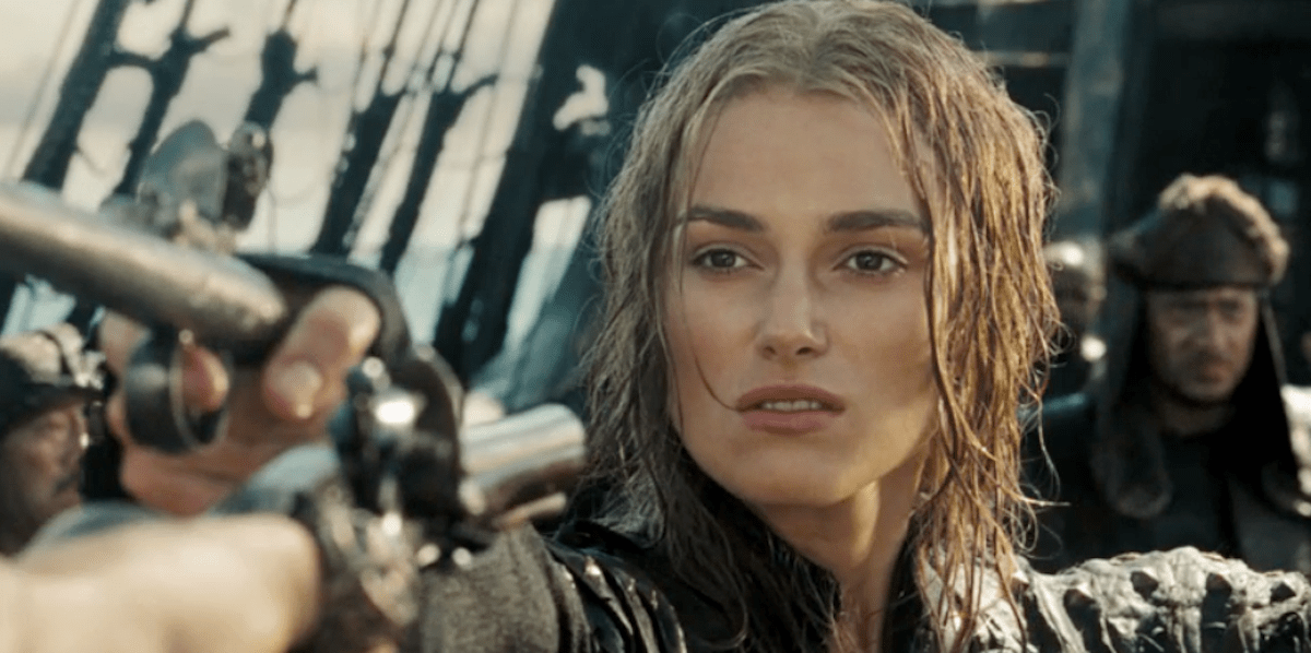 A white woman with wet hair points a gun while standing on a ship in the "Pirates of the Caribbean" franchise films