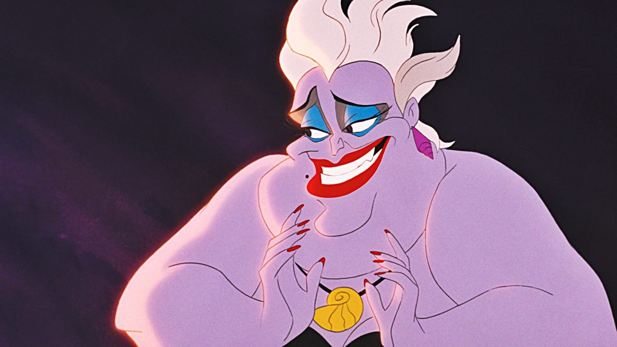 Ursula smiles and holds her hands up in the little mermaid.