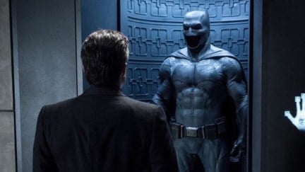 Bruce Wayne looking at his Batman suit.