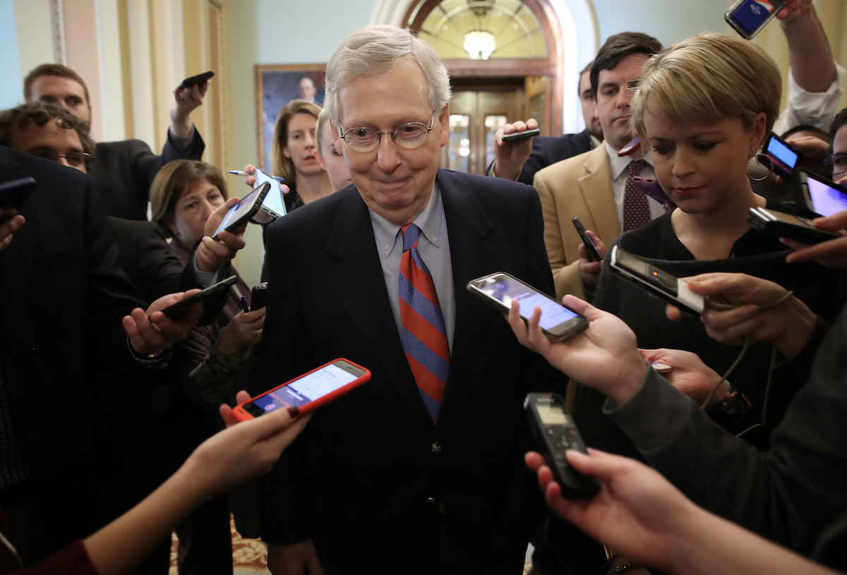 Senate Majority Leader Mitch McConnell (R-KY) smiles while talking with reporters
