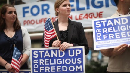 Religious freedom protesters with signs and American flags.