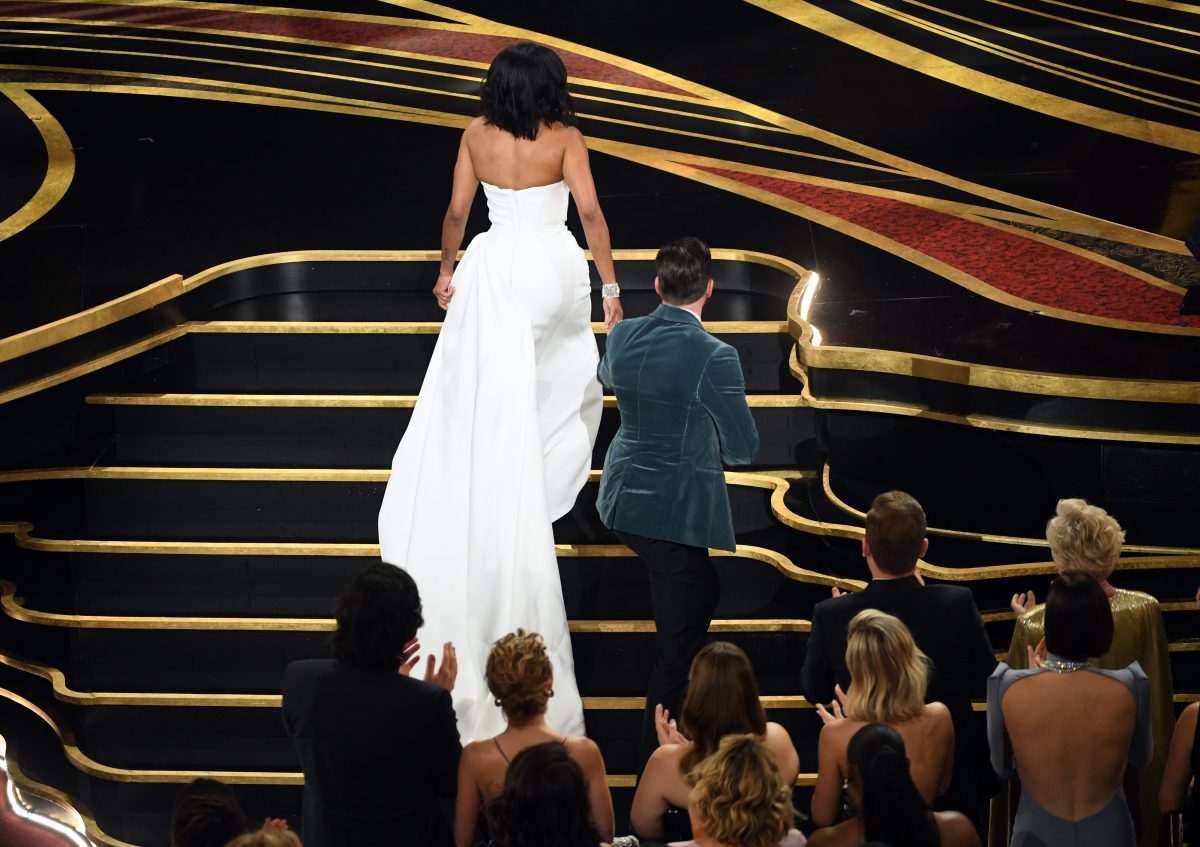 Chris Evans helping Regina King onto the Oscars stage.