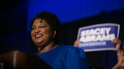 Stacey Abrams with campaign sign behind her