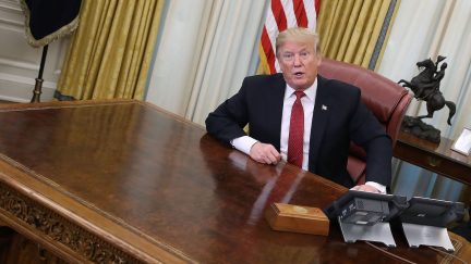 donald trump sits at an empty desk