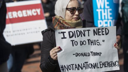 Protestor holds a sign reading 