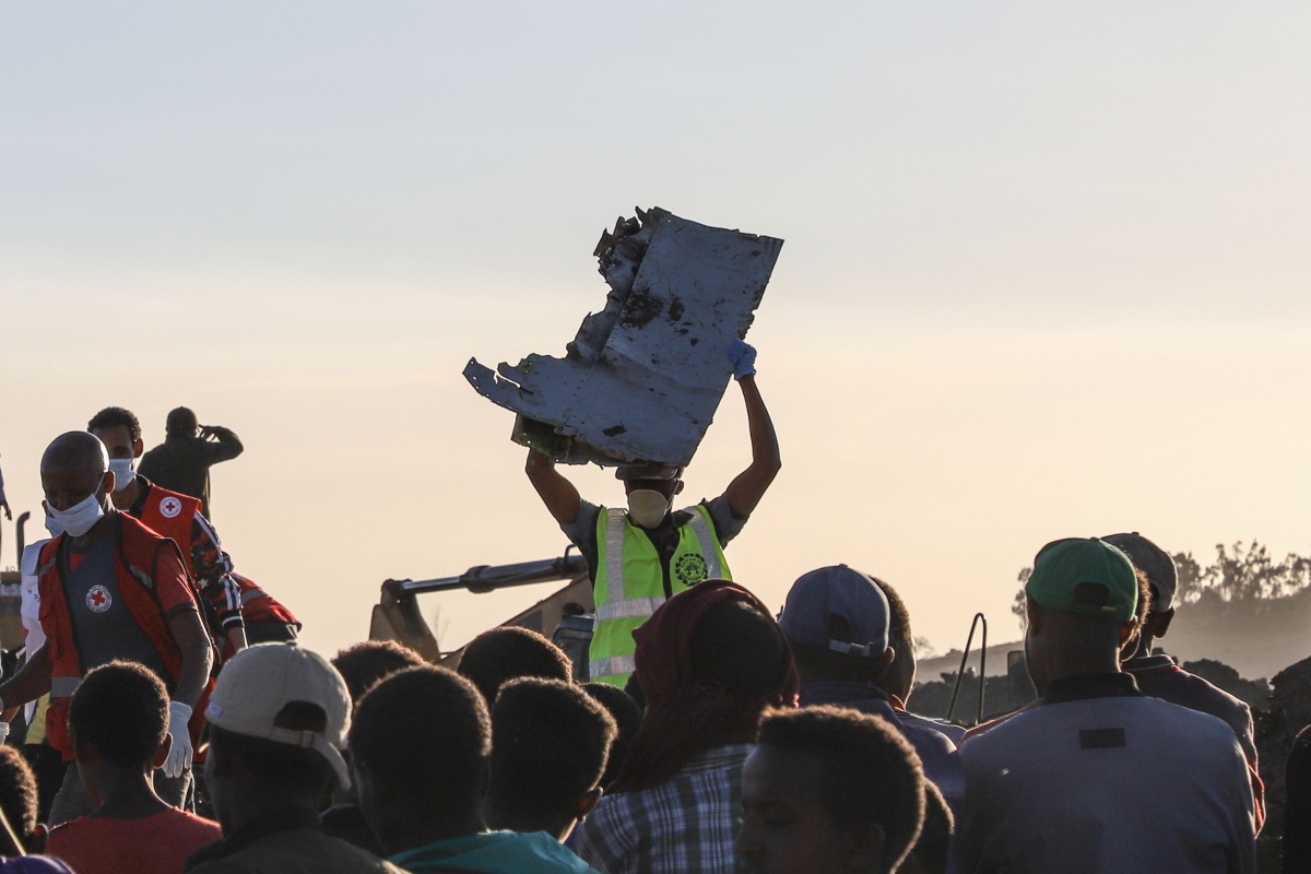 TOPSHOT - A man carries a piece of debris on his head at the crash site of a Nairobi-bound Ethiopian Airlines flight near Bishoftu, a town some 60 kilometres southeast of Addis Ababa, Ethiopia, on March 10, 2019. - A Nairobi-bound Ethiopian Airlines Boeing crashed minutes after takeoff from Addis Ababa on March 10, killing all eight crew and 149 passengers on board, including tourists, business travellers, and "at least a dozen" UN staff. (Photo by Michael TEWELDE / AFP) (Photo credit should read MICHAEL TEWELDE/AFP/Getty Images)