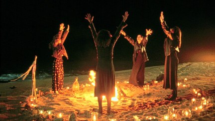 Fairuza Balk, Neve Campbell, Robin Tunney, and Rachel True hold their hands up around a fire in The Craft (1996)