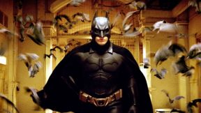 Christian Bale, flocked by bats, in Batman Begins.
