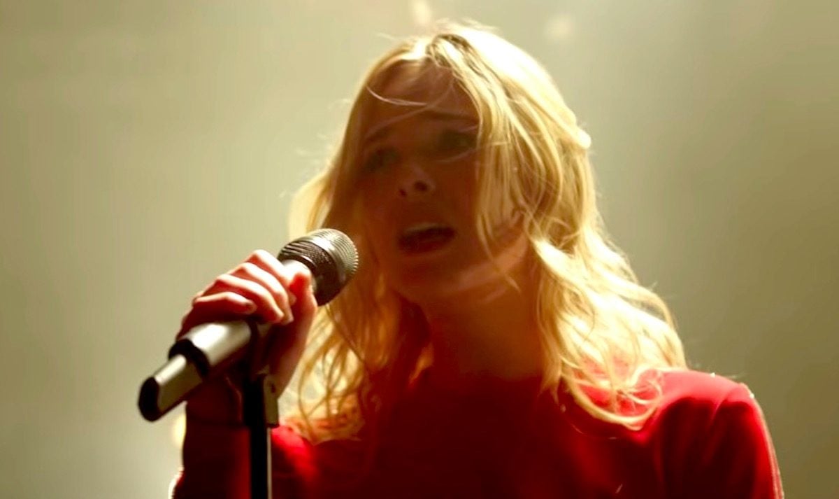 Elle Fanning singing into a microphone in Teen Spirit movie.
