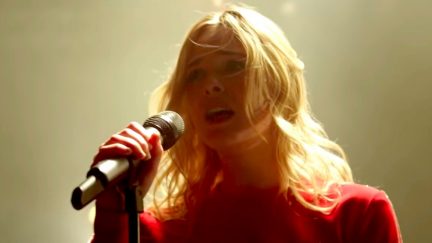 Elle Fanning singing into a microphone in Teen Spirit movie.