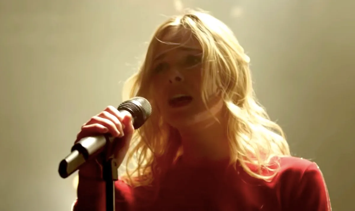 Elle Fanning singing into a microphone in Teen Spirit movie.
