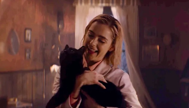 Sabrina smiles while holding Salem in Chilling Adventures of Sabrina.
