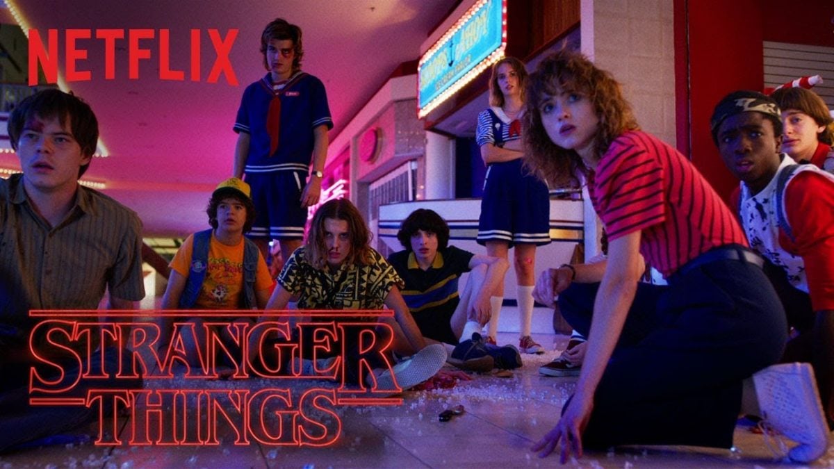 The cast of Stranger Things season 3 all staring at something unknown.