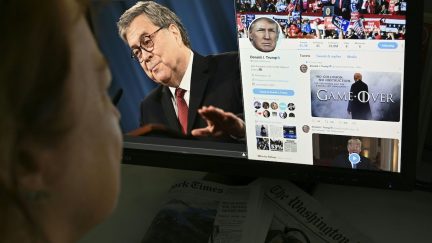 A photo illustration dated April 18, 2019 in Washington, DC shows an editor looking at a photograph of US Attorney General William Barr (L) speaking about the release of the redacted version of the Mueller report, juxtaposed with US President Donald Trump's latest tweet (R) 