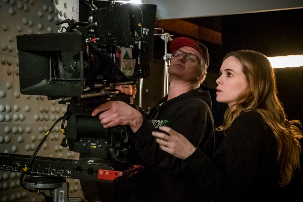 Danielle Panabaker looks into the back of a camera on the set of The Flash.