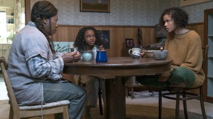 Fast color movie still the whole family sits around a table.