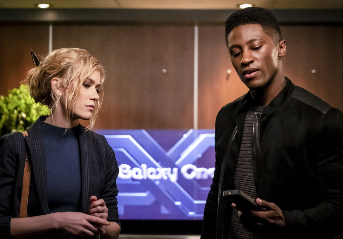 Katherine McNamara as Mia/Blackstar and Joseph David Jones as Connor Hawke looking at a phone screen on The CW's Arrow.