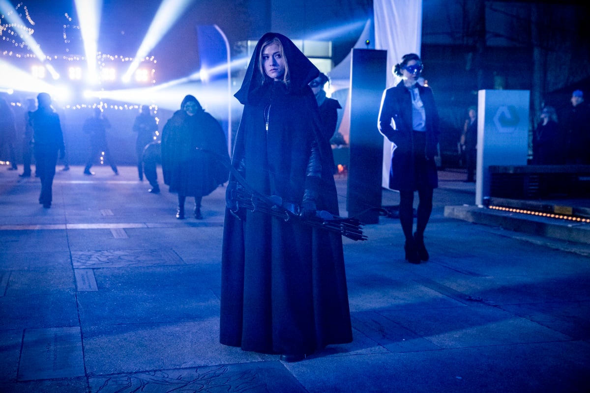 Mia Smoak in a cloak, holding a bow in The CW's Arrow.