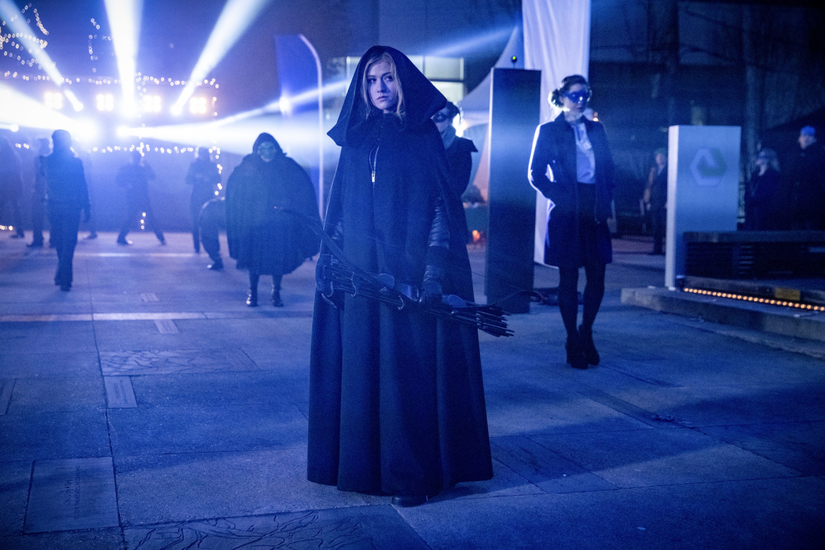 Mia Smoak in a cloak, holding a bow in The CW's Arrow.