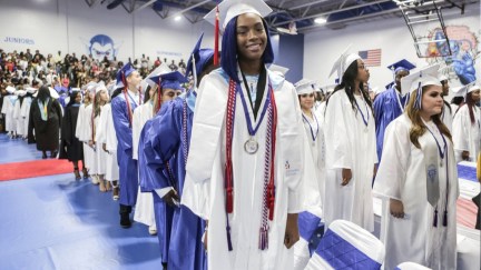 Pahokee high students standing in graduation gowns in the auditorium.