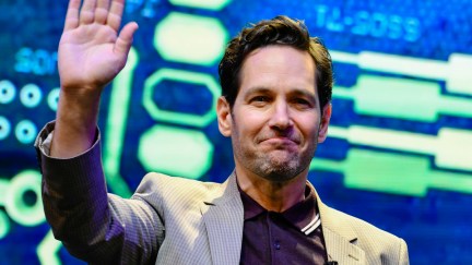 Paul Rudd waves in front of a colorful backdrop