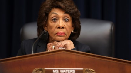 Congresswoman Maxine Waters rests her head on her chin, fresh out of patience, above a plaque reading Chairwoman.