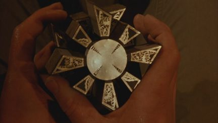Hellraiser puzzle box being held by Frank Cotton, a douchebag.