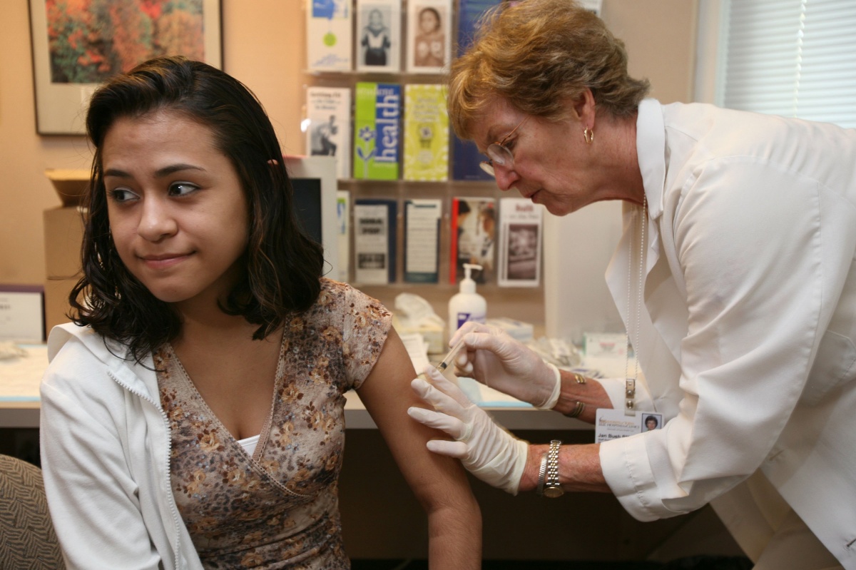 University of Iowa junior Erica Zamudil, 22, (L) receives a mumps, measles and rubella vaccination shot from nurse Jan Bush at the school's Student Health Service April 27, 2006 in Iowa City, Iowa. Mass vaccination clinics were set up in college towns across Iowa as public health officials try to contain a mumps epidemic. The University of Iowa has had 62 confirmed cases of mumps. (Photo by Mark Kegans/Getty Images)